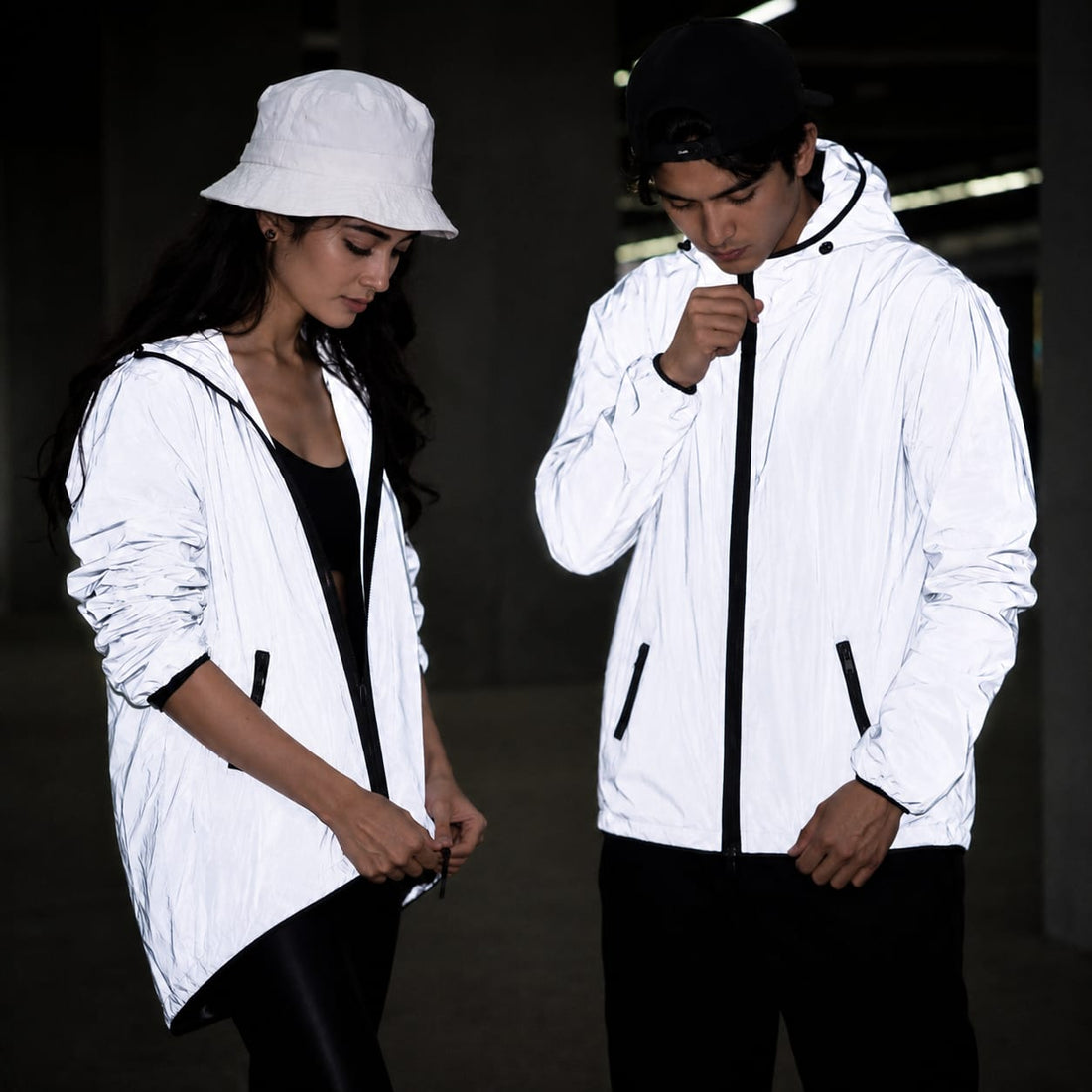 Retro-reflective windbreaker glowing white at night under flash — night safety for bikers and runners